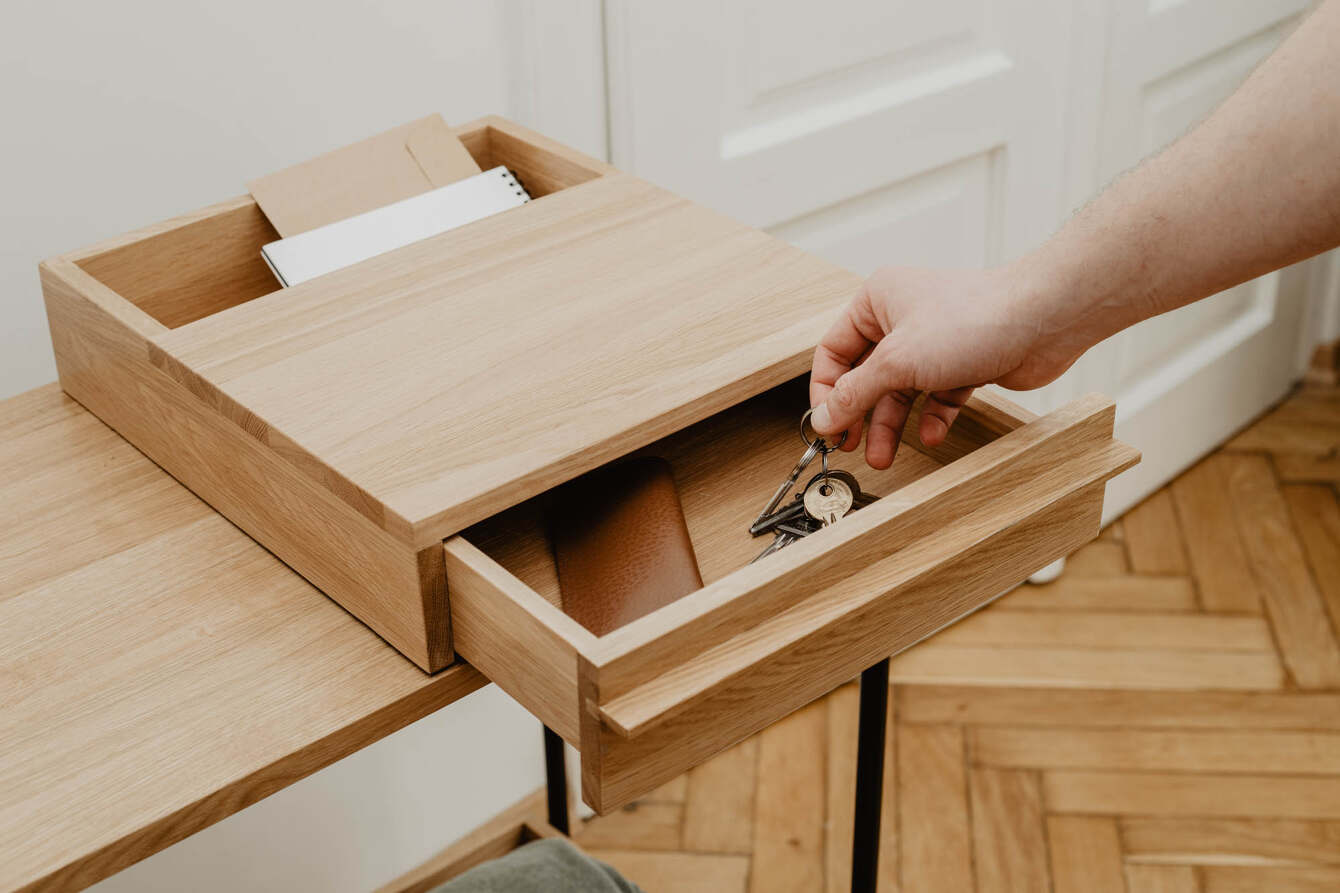 Man putting keys into an open drawer