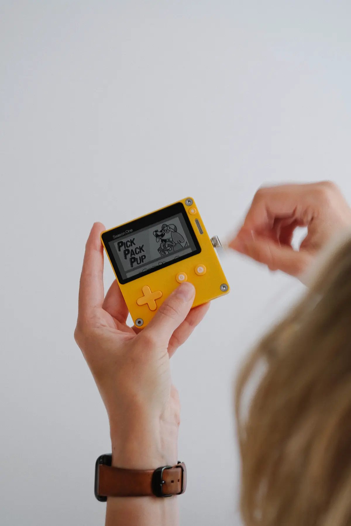 woman spinning crank on playdate console
